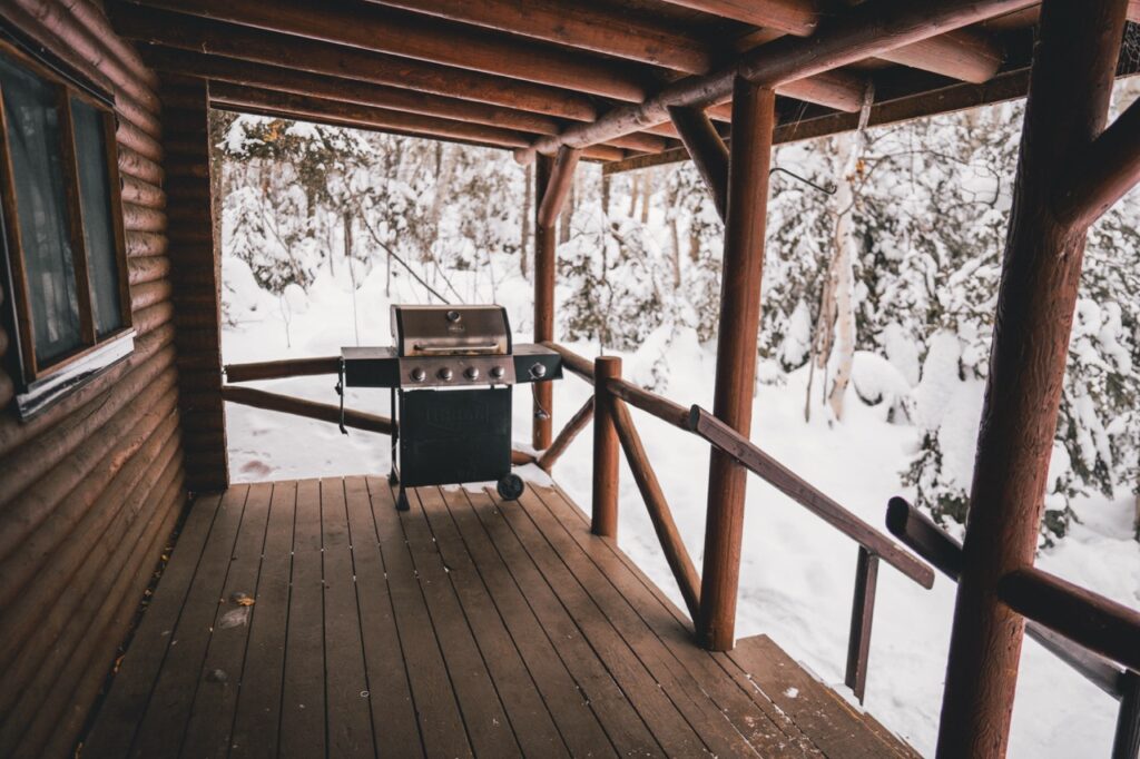 Front porch of a winterized cabin providing reliable accommodations for extended stays during construction projects.