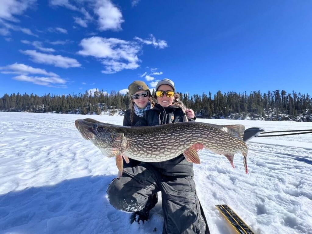 Two women holding a large ice fishing catch