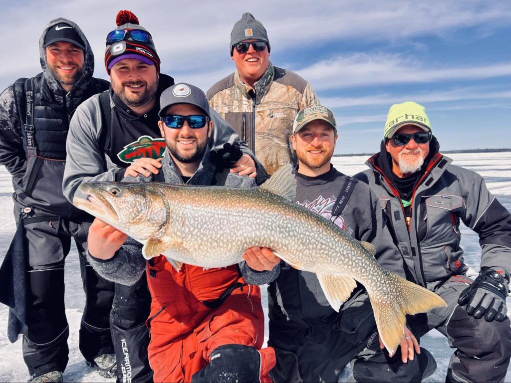 Group of anglers celebrating a big catch at a Manitoba Ice Fishing Lodge.
