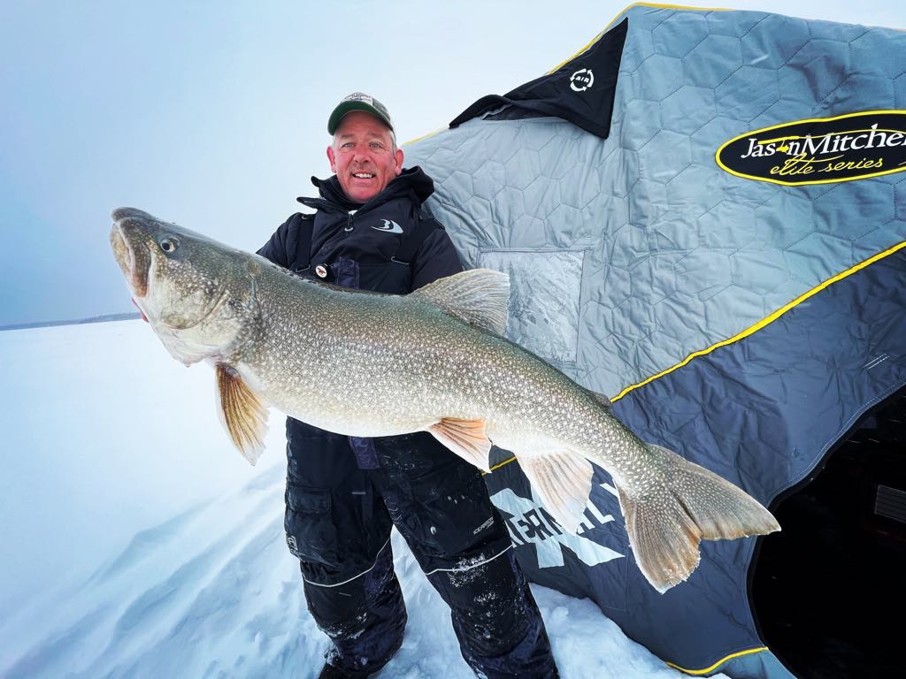 Angler holding a trophy lake trout caught at Lake Athapapuskow.