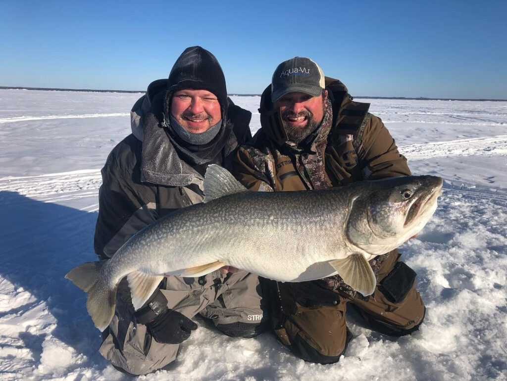 Two men happily anglers holding a big fish they caught at Lake Athapapuskow