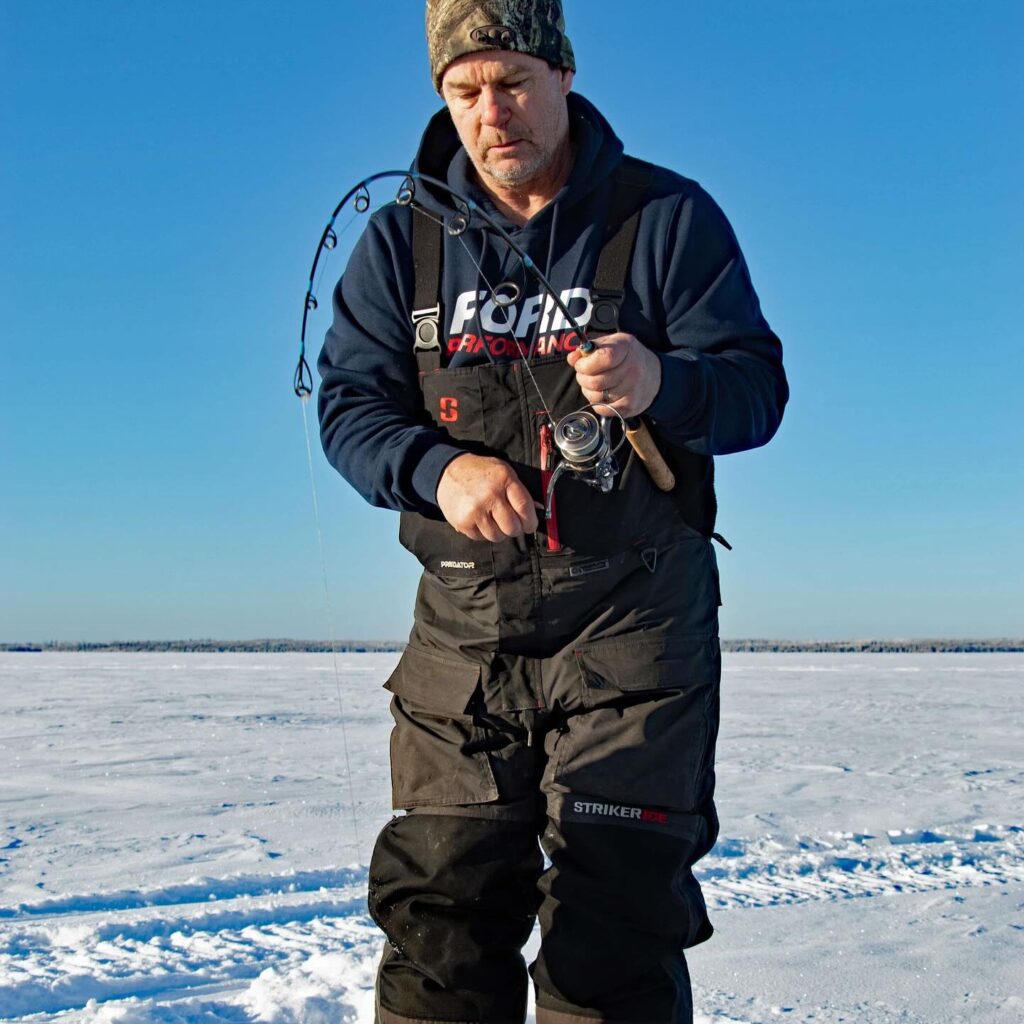 a man ice fishing at Lake Athapapuskow