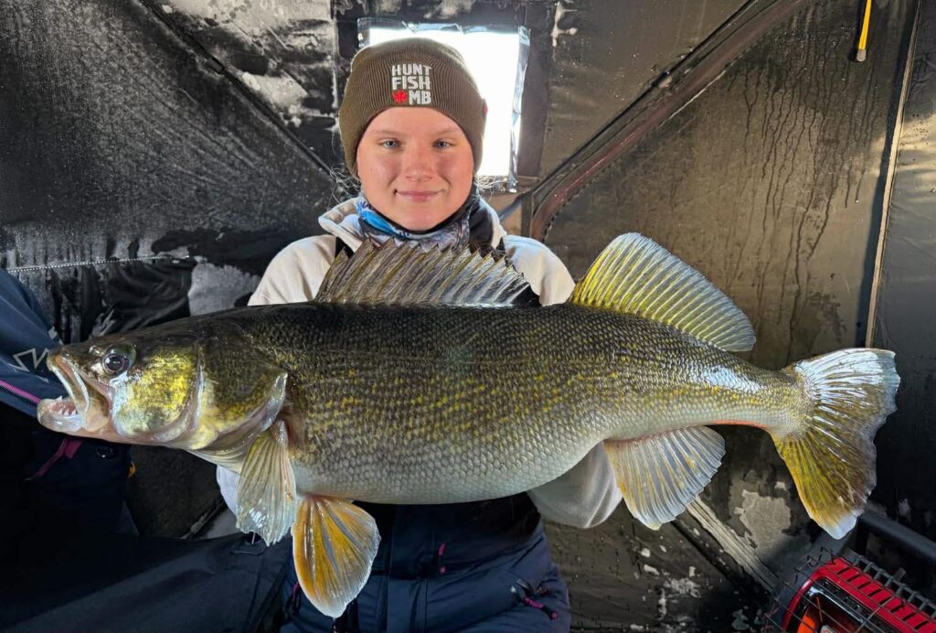 a young boy holding a big fish caught at Lake Athapapuskow