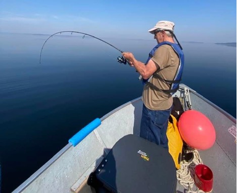 A man fishing from a boat, demonstrating the flexible angling options available at a top Manitoba lodge.