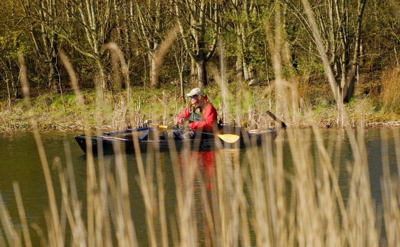 Kayak fisher among the reeds