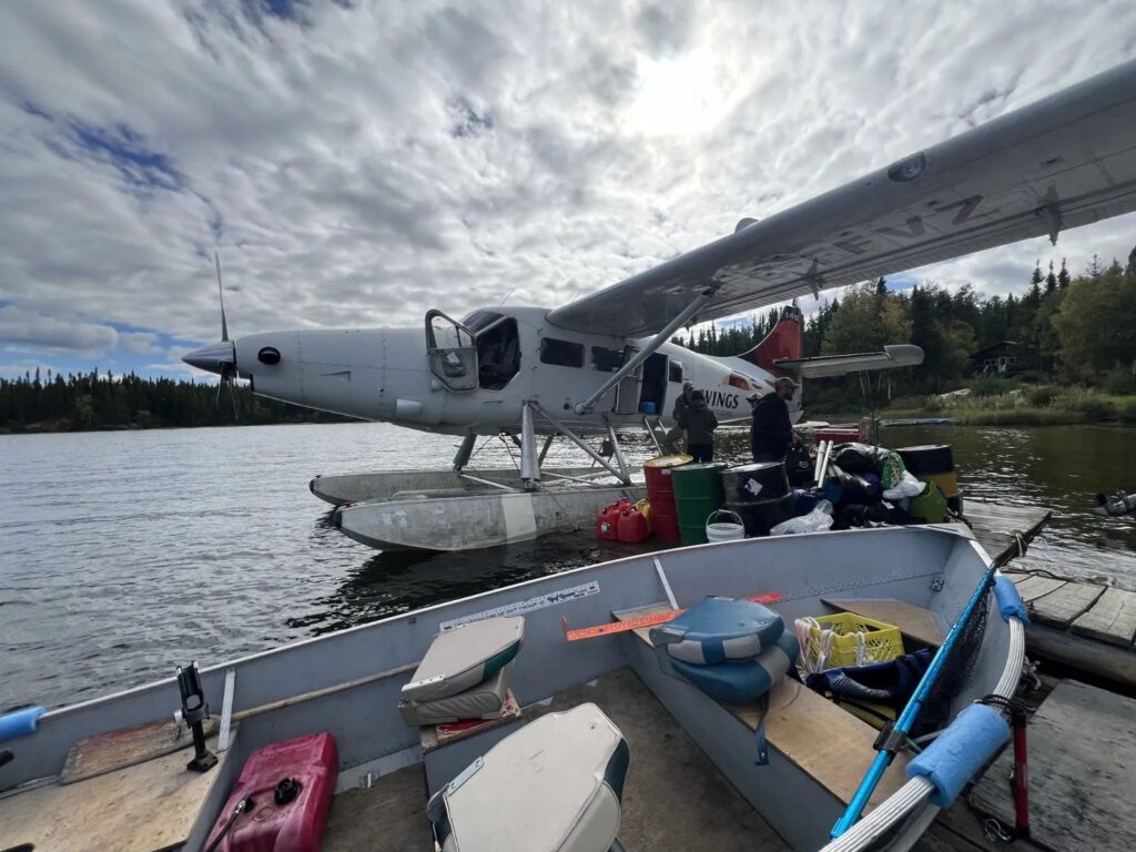 Unloading gear from the Wings Over Kississing floatplane at the Kamuchawie Lake outpost