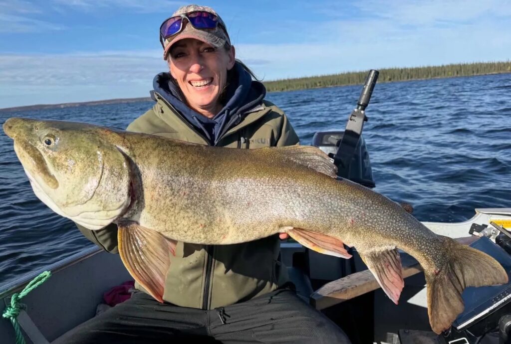 Christina, the outpost cook, holding a lake trout over 40 inches on Kamuchawie Lake