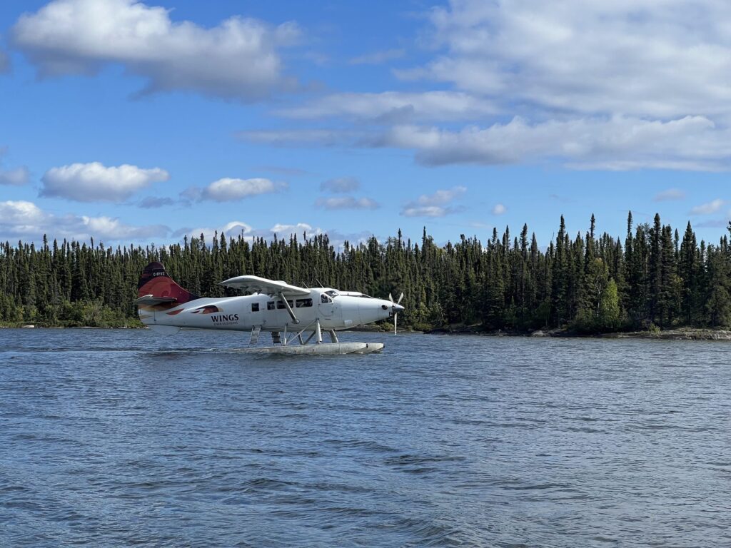 Wings Over Kississing floatplane taxiing on Kamuchawie Lake in summer
