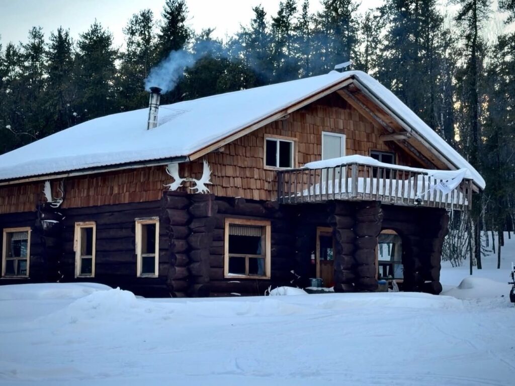 Kamuchawie Lake outpost lodge in winter with smoke rising from the wood stove
